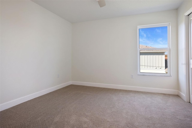 unfurnished room with carpet, a ceiling fan, and baseboards