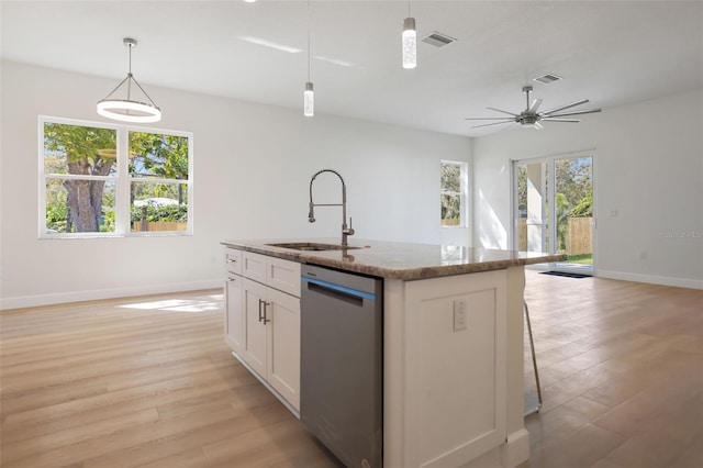 kitchen featuring stainless steel dishwasher, visible vents, open floor plan, and a sink