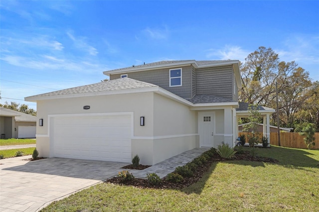 view of front of property with a garage, fence, decorative driveway, stucco siding, and a front yard