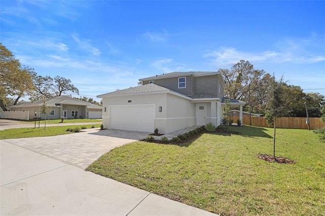 view of front of home featuring an attached garage, fence, decorative driveway, stucco siding, and a front yard