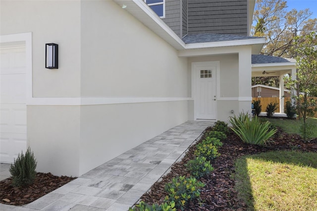 property entrance with roof with shingles and stucco siding