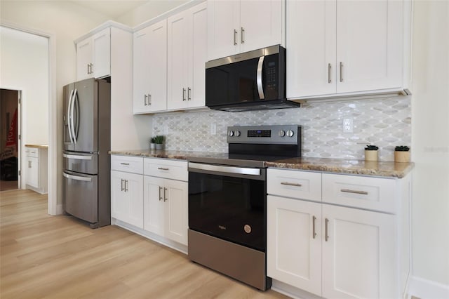 kitchen with stone counters, light wood finished floors, stainless steel appliances, decorative backsplash, and white cabinets