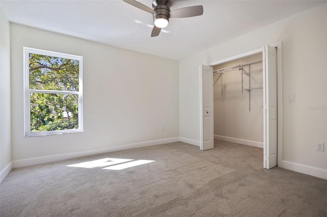 unfurnished bedroom featuring ceiling fan, a closet, carpet, and baseboards