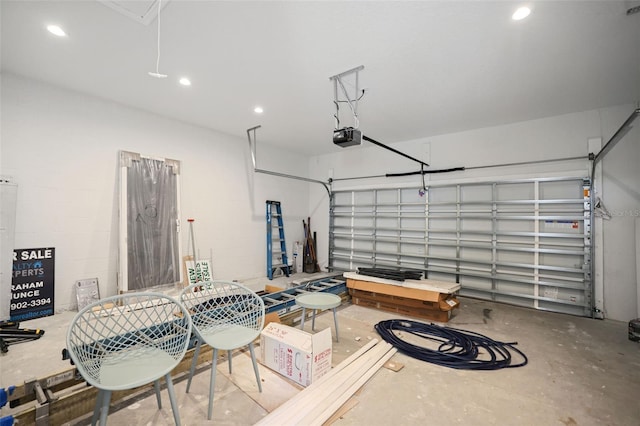 garage with concrete block wall, recessed lighting, and a garage door opener