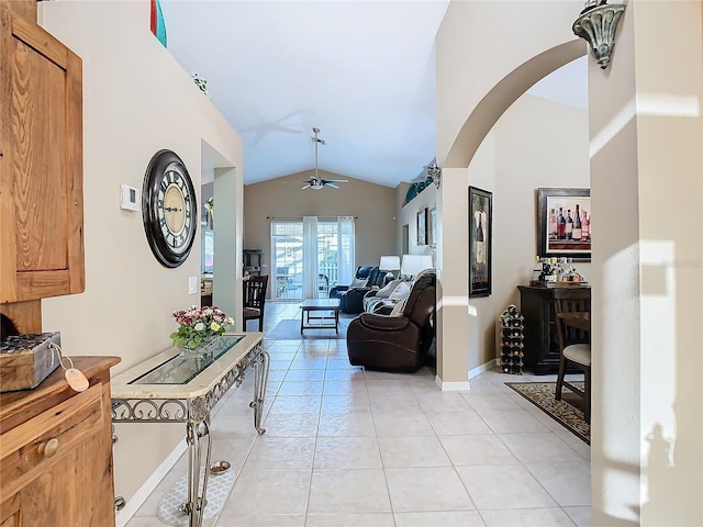 hall featuring light tile patterned flooring and vaulted ceiling