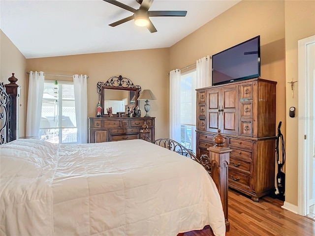 bedroom featuring multiple windows, ceiling fan, lofted ceiling, and light wood-type flooring