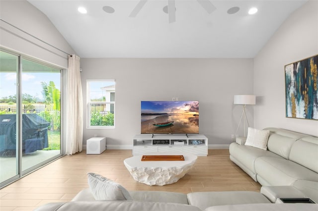 living room with ceiling fan, light wood-type flooring, and vaulted ceiling