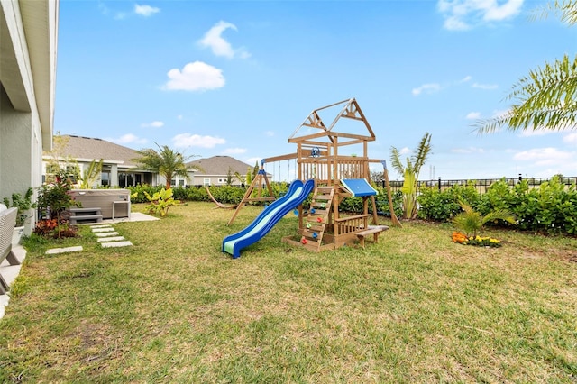 view of playground with a hot tub and a lawn