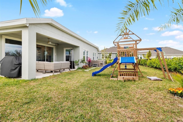 view of play area featuring a lawn, outdoor lounge area, ceiling fan, a hot tub, and a patio