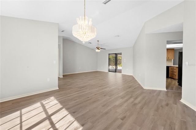 unfurnished living room with ceiling fan with notable chandelier, light hardwood / wood-style floors, and lofted ceiling