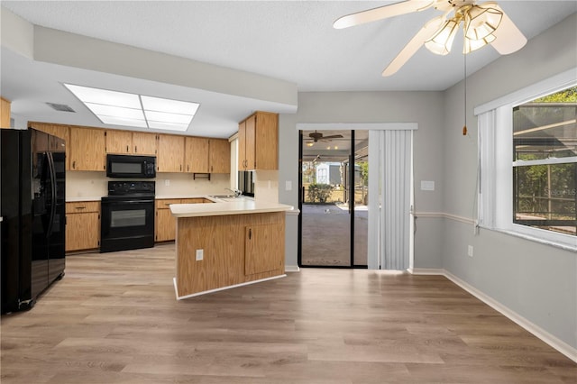 kitchen with black appliances, ceiling fan, light wood-type flooring, and kitchen peninsula