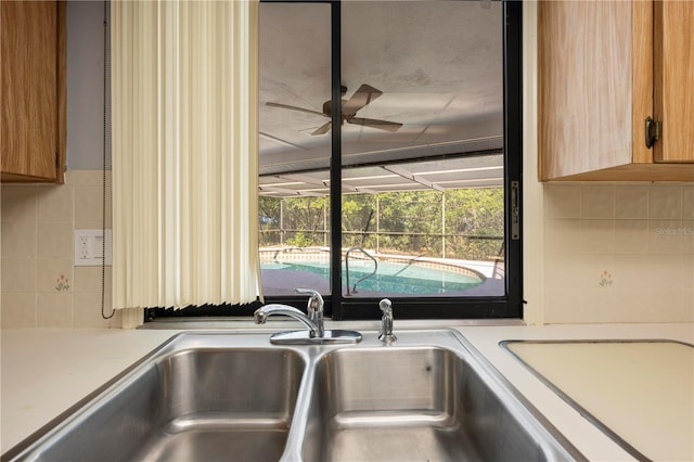 interior details with decorative backsplash, ceiling fan, and sink