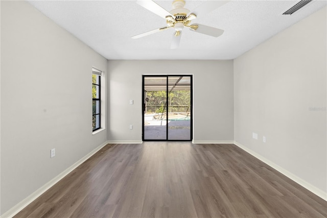 spare room featuring a textured ceiling, dark hardwood / wood-style floors, and ceiling fan