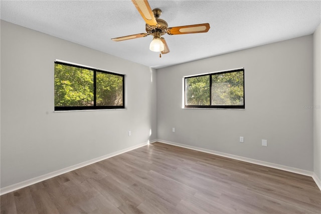 empty room featuring hardwood / wood-style flooring, ceiling fan, and a textured ceiling