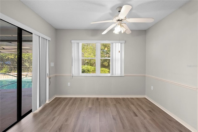 empty room featuring hardwood / wood-style flooring, ceiling fan, and a textured ceiling