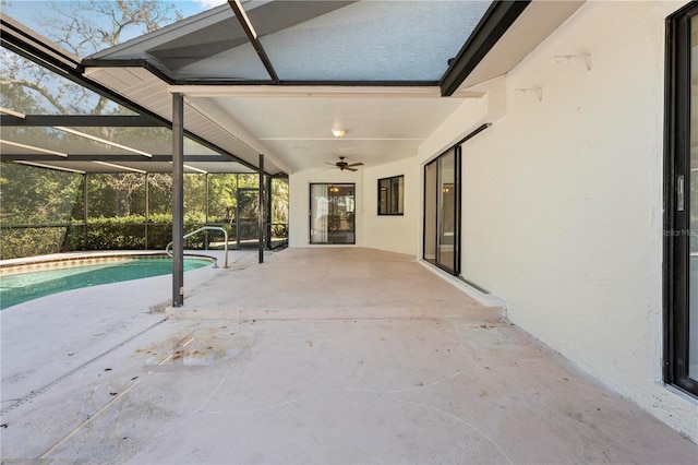 view of pool with glass enclosure, ceiling fan, and a patio