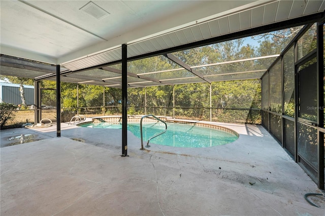 view of swimming pool with glass enclosure and a patio