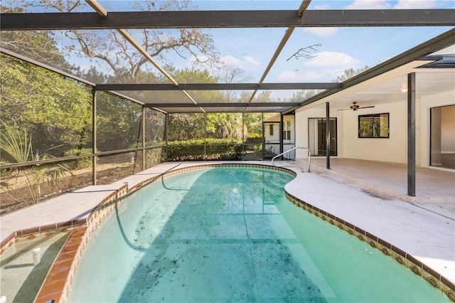 view of pool featuring glass enclosure, ceiling fan, and a patio area