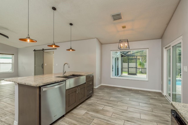 kitchen featuring sink, pendant lighting, stainless steel dishwasher, and a barn door