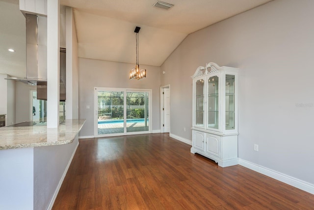 unfurnished dining area featuring an inviting chandelier, dark hardwood / wood-style flooring, and lofted ceiling