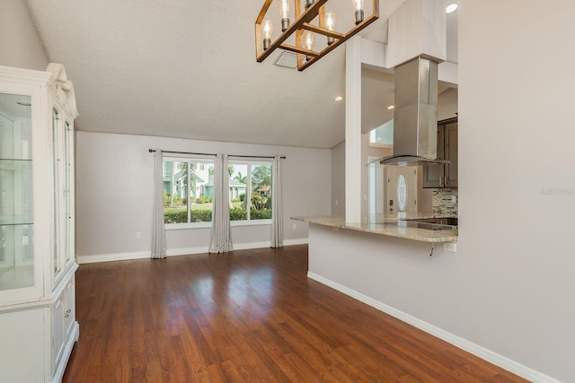 unfurnished living room with a textured ceiling, dark hardwood / wood-style flooring, and lofted ceiling