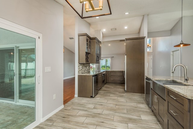 kitchen featuring dishwasher, sink, backsplash, hanging light fixtures, and light stone counters