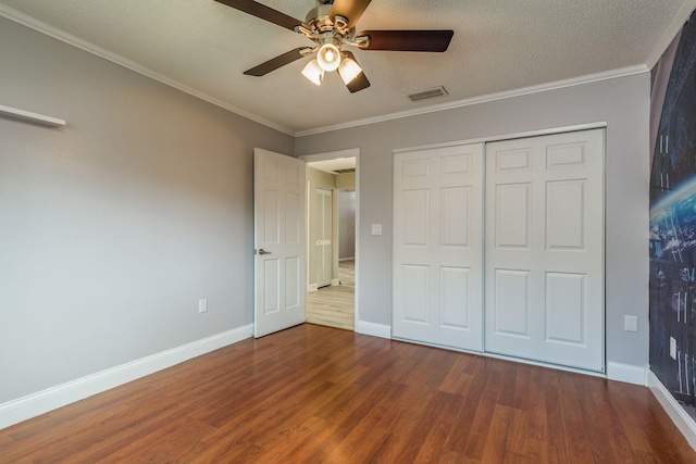 unfurnished bedroom with ceiling fan, wood-type flooring, a closet, and ornamental molding