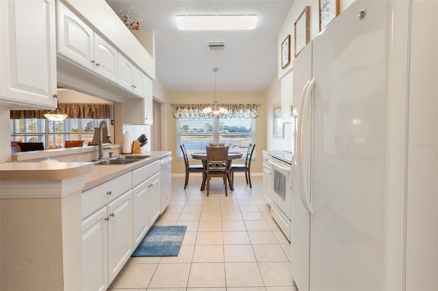 kitchen with sink, white cabinetry, a textured ceiling, light tile patterned floors, and white appliances