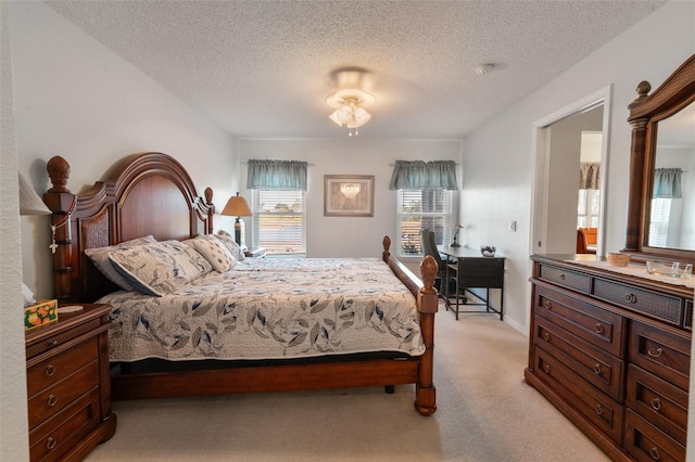 bedroom with light colored carpet and a textured ceiling