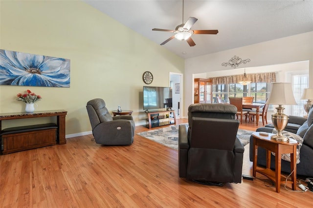 living room featuring ceiling fan, high vaulted ceiling, and light wood-type flooring