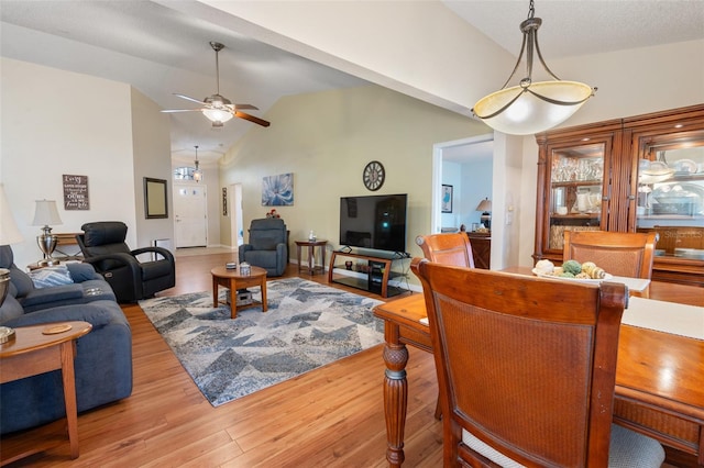 living room featuring vaulted ceiling, ceiling fan, and light hardwood / wood-style flooring