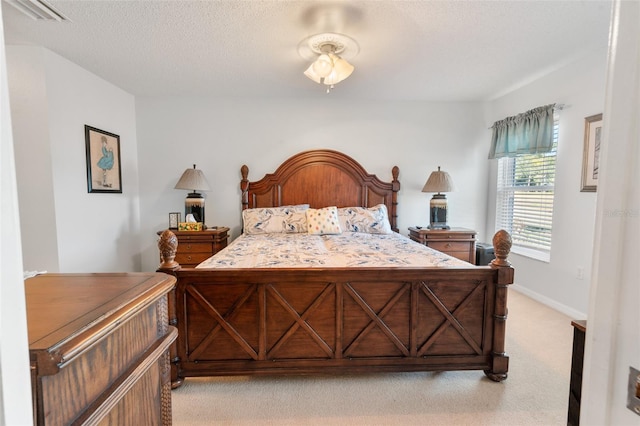 bedroom with light carpet and a textured ceiling