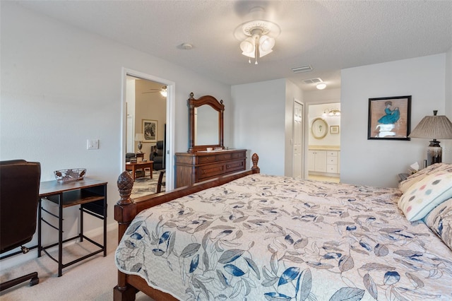 carpeted bedroom with a textured ceiling, ceiling fan, and ensuite bathroom