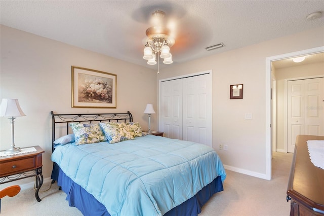 carpeted bedroom featuring a textured ceiling, a closet, and ceiling fan