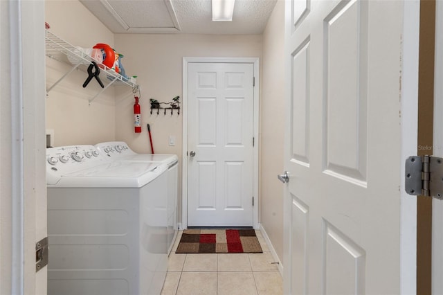 washroom with washing machine and clothes dryer and light tile patterned flooring