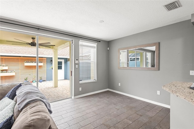 unfurnished living room featuring a textured ceiling, dark hardwood / wood-style flooring, and ceiling fan