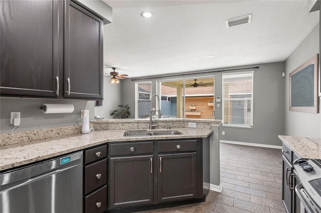 kitchen featuring light stone countertops, sink, dark brown cabinets, and appliances with stainless steel finishes