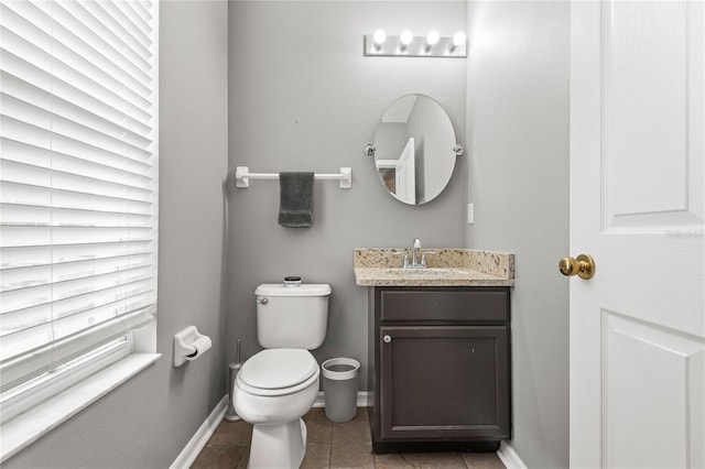 bathroom with toilet, vanity, and tile patterned floors