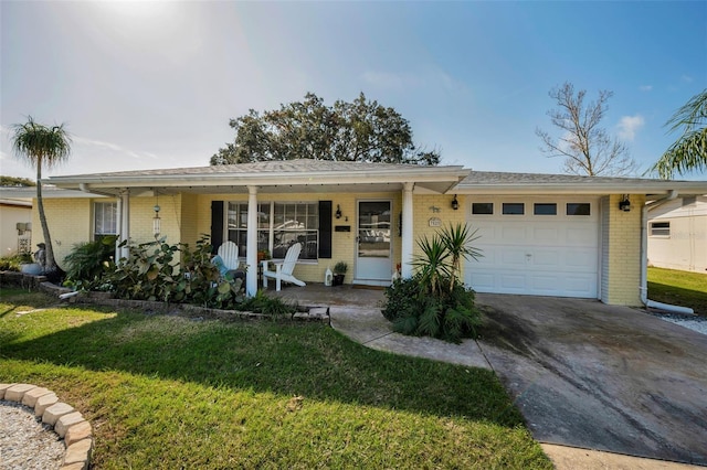 ranch-style house featuring covered porch, a garage, and a front yard