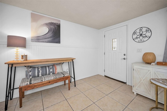 tiled foyer entrance with a textured ceiling