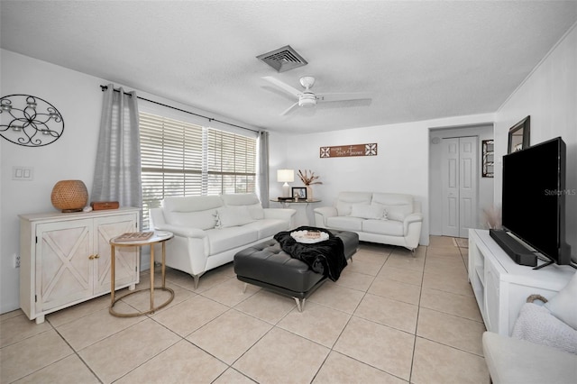 tiled living room with ceiling fan and a textured ceiling