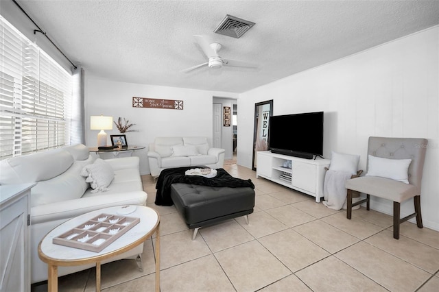 living room featuring light tile patterned floors, a textured ceiling, and ceiling fan