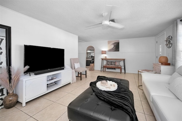 living room with light tile patterned floors, a textured ceiling, and ceiling fan