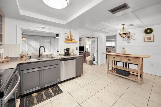 kitchen with gray cabinetry, stainless steel appliances, sink, light tile patterned floors, and a chandelier