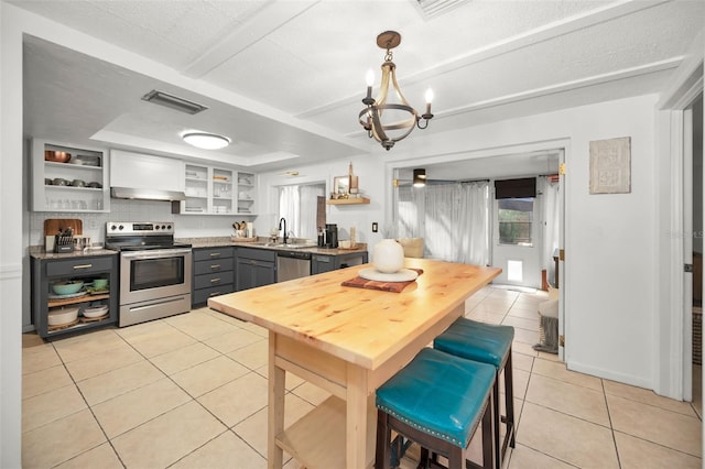 kitchen with gray cabinetry, stainless steel appliances, sink, a notable chandelier, and light tile patterned flooring