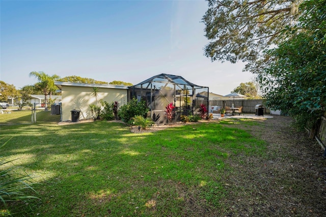 view of yard with glass enclosure and a patio area