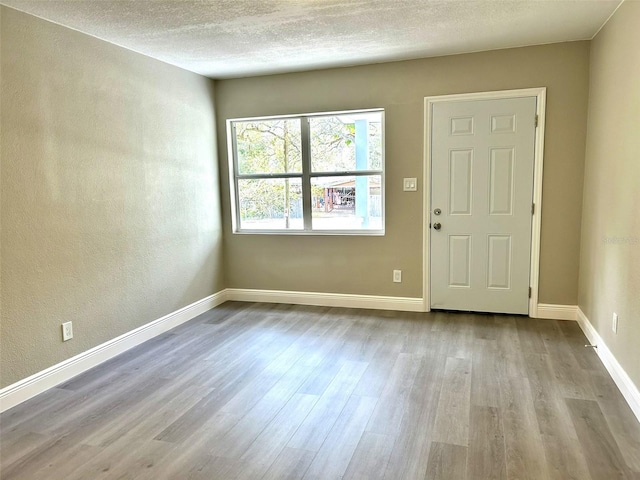 entrance foyer with light hardwood / wood-style floors and a textured ceiling