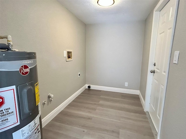 washroom with light hardwood / wood-style flooring, washer hookup, a textured ceiling, water heater, and hookup for an electric dryer