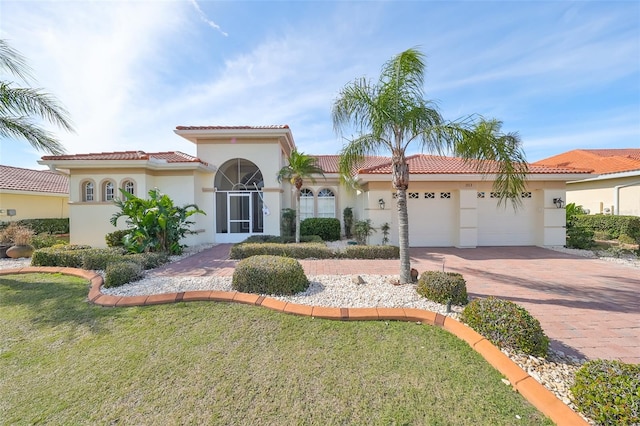 mediterranean / spanish-style home featuring a front yard and a garage