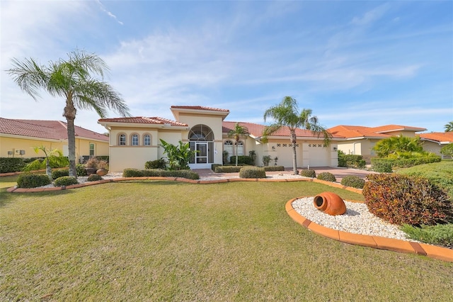 mediterranean / spanish home with a garage and a front lawn